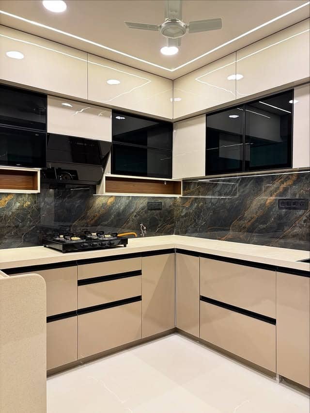 20. Glossy Beige Kitchen with Black Marble Backsplash - light color kitchen ideas