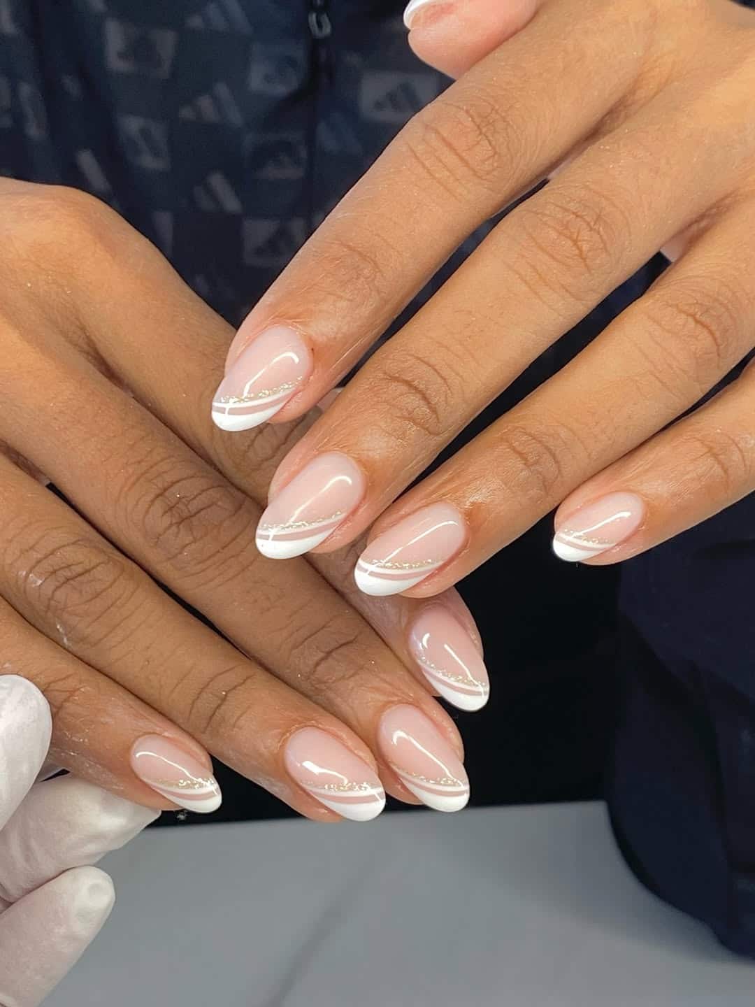 7. Curved White French Nails with Gold Stripe - trendy simple nail ideas