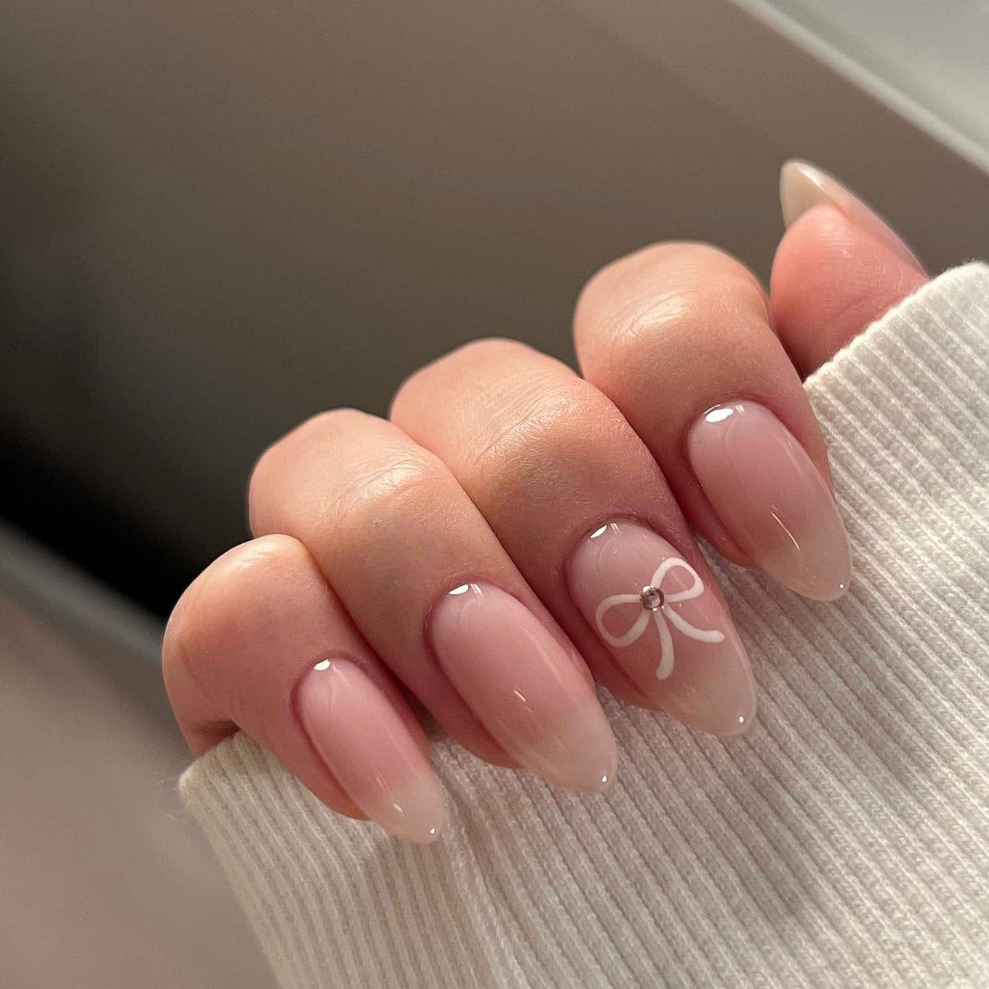 22. Milky Pink Almond Nails with White Bow Accent - trendy simple nail ideas
