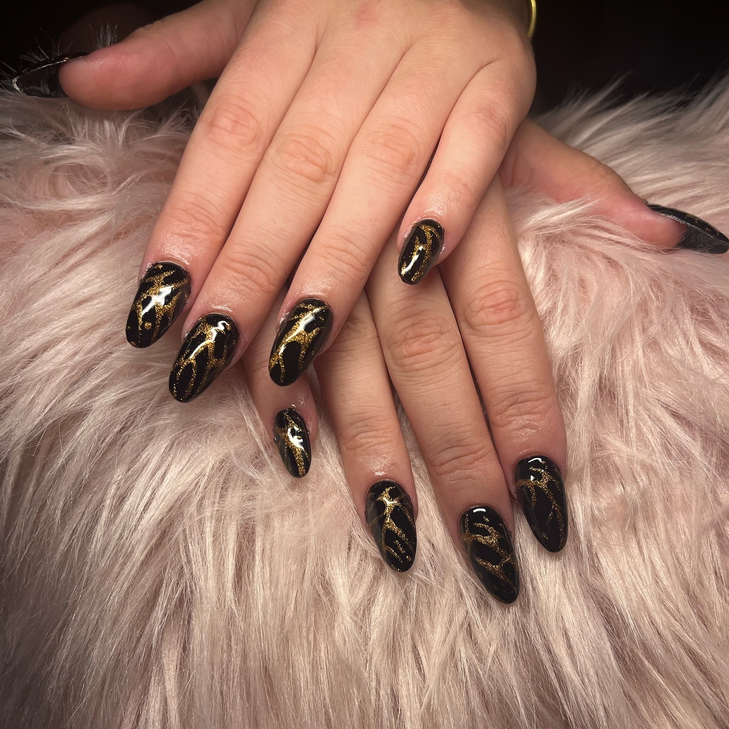 2. Black Almond Nails with Gold Marble Swirls - black and gold nail ideas