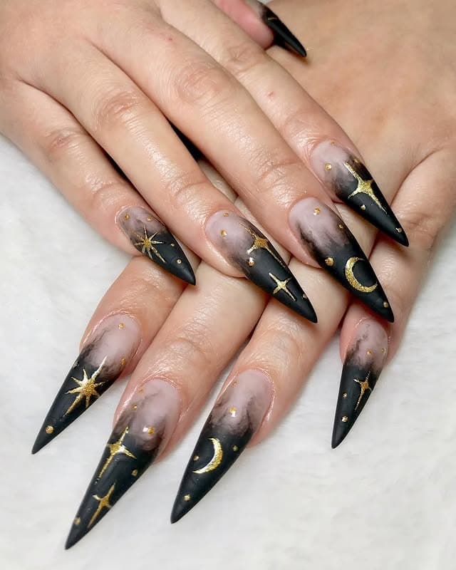 3. Black Celestial Stiletto Nails with Gold Stars - black and gold nail ideas