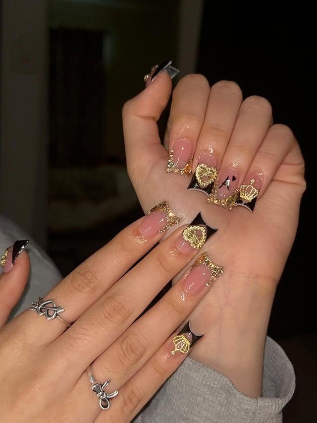 5. Black French Nails with Gold Heart Charms - black and gold nail ideas