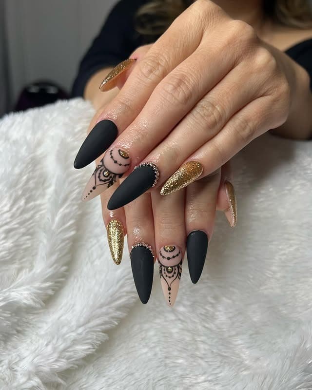 6. Matte Black Stiletto Nails with Gold Glitter - black and gold nail ideas