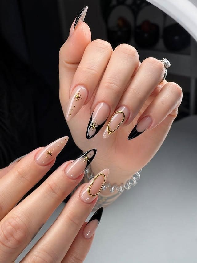 22. Black French Stiletto Nails with Gold Celestial Details - black and gold nail ideas