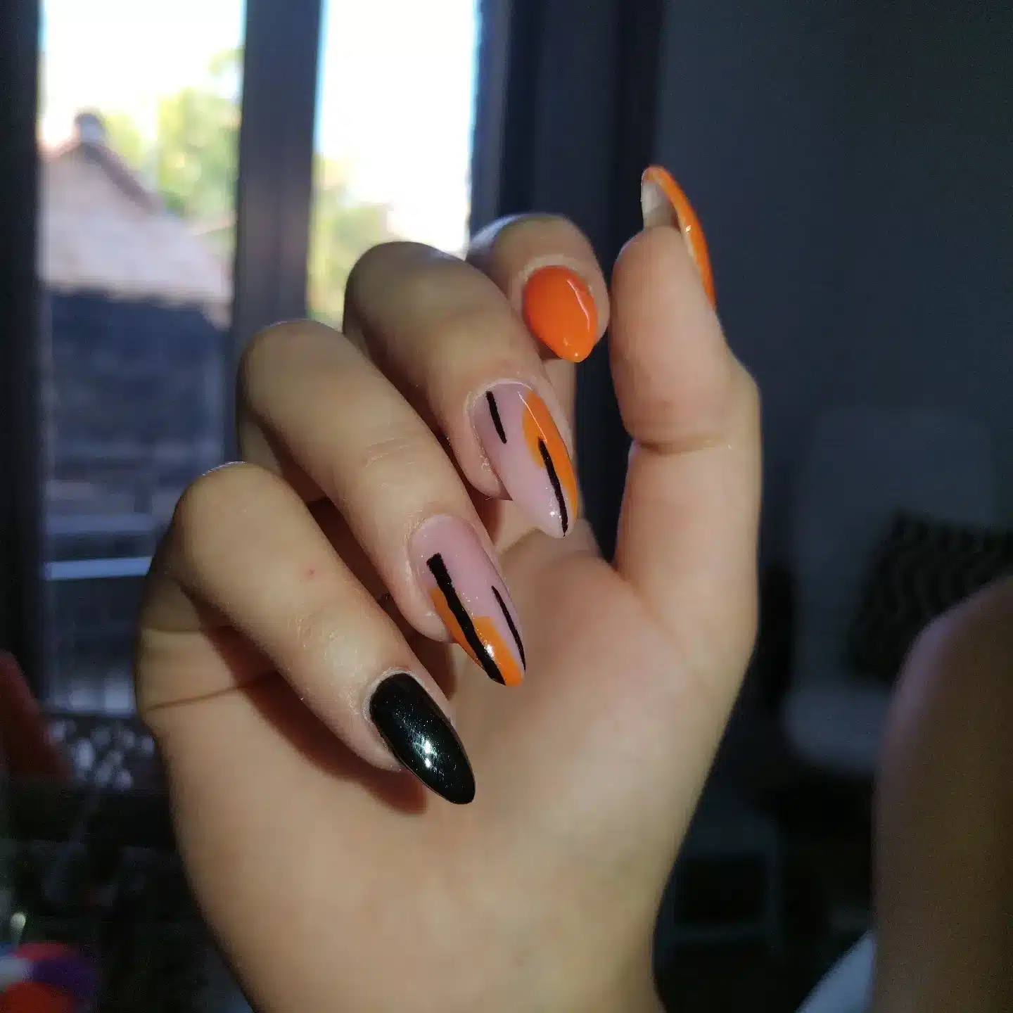 4. Orange and Black Graphic Oval Nails - oval nail ideas
