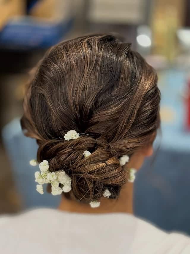 9. Medium Brown Twisted Low Messy Bun with Baby's Breath - Messy Bun Hairstyles