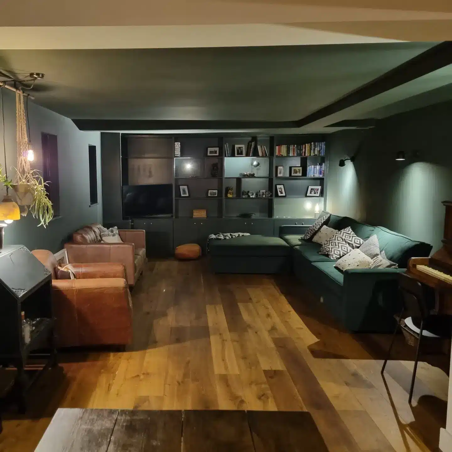 19. Moody Dark Green Living Room with Leather Chairs - dark green living room ideas