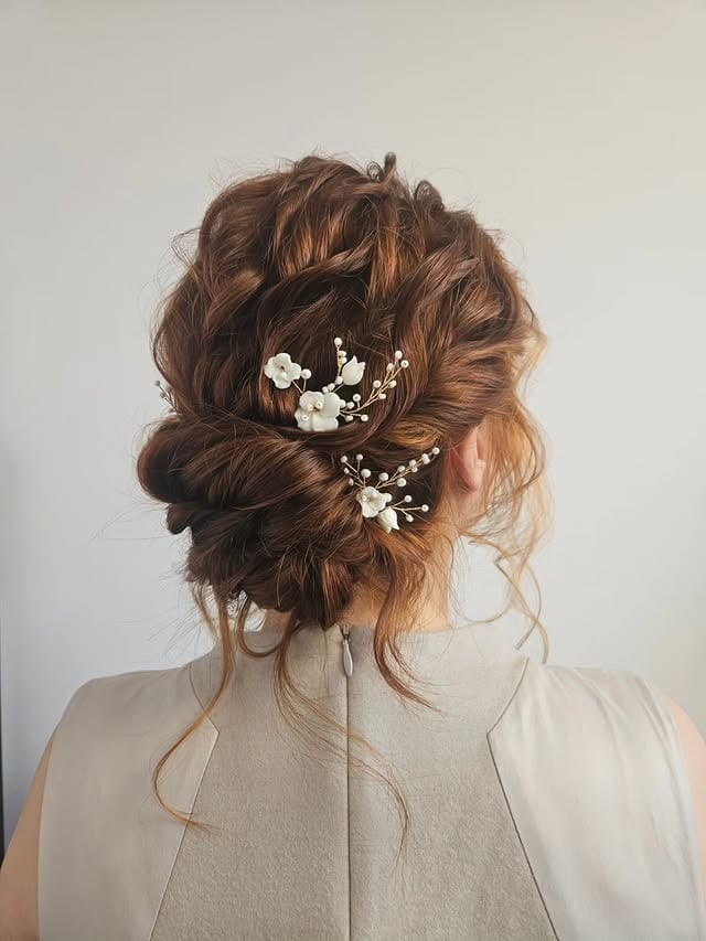 3. Textured Auburn Low Chignon with Floral Pins - Wedding Hairstyles