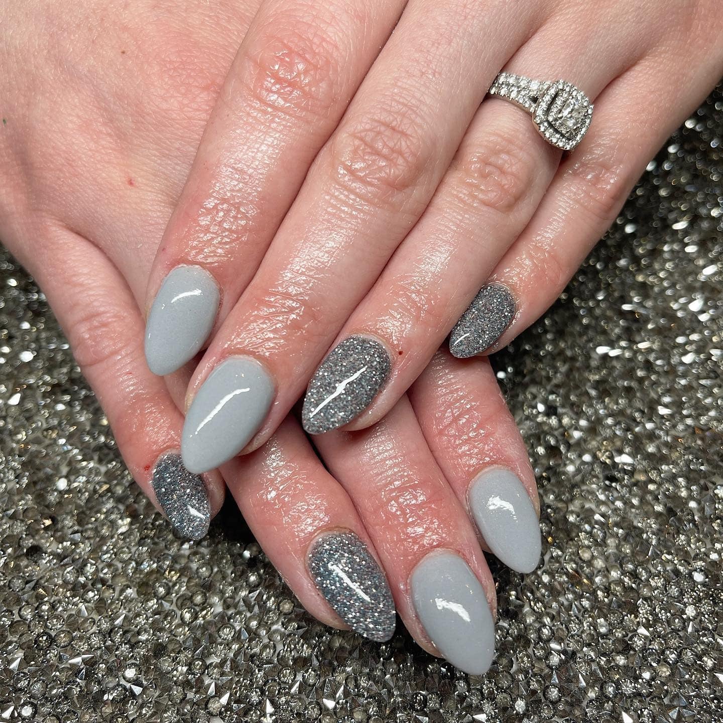 1. Glossy Gray Almond Nails with Silver Glitter Accents - gray nail ideas