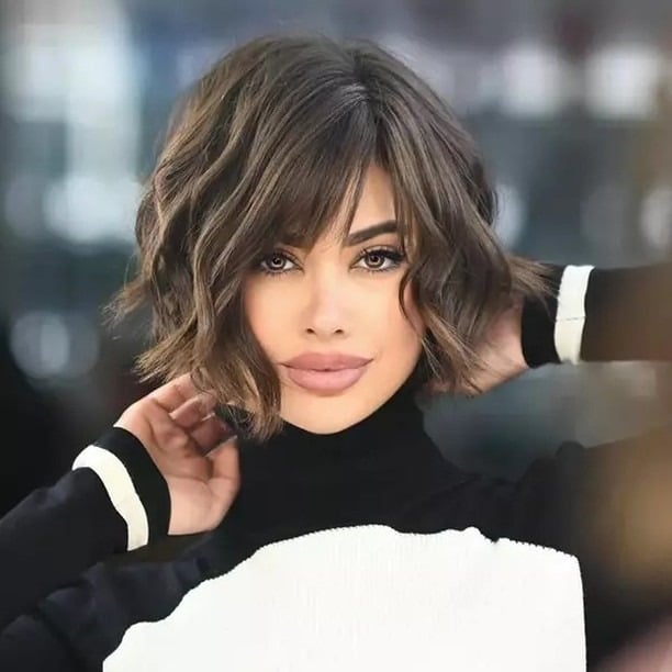 17. Ash Brown Wavy Bob with Wispy Bangs - Short Wavy Hairstyles
