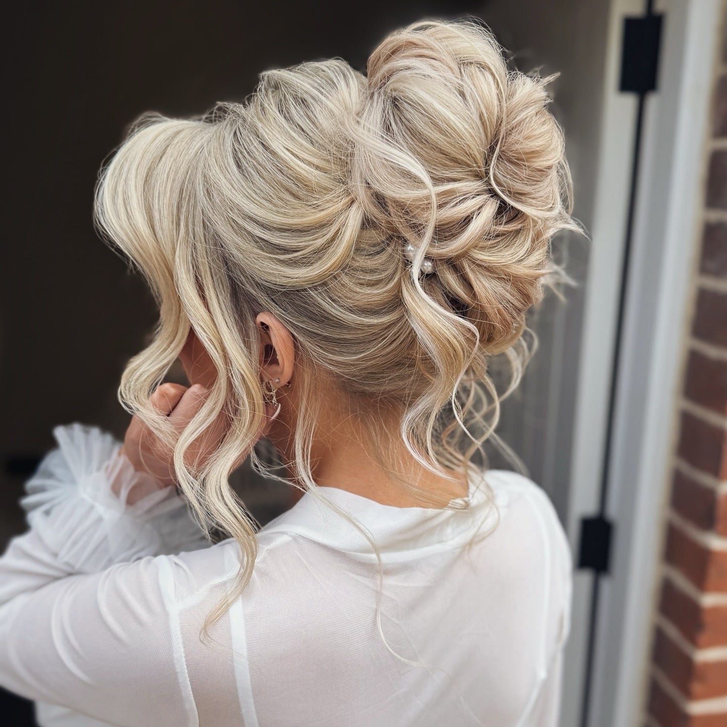 8. Glam Blonde High Bun with Loose Curls - Bride Hairstyles