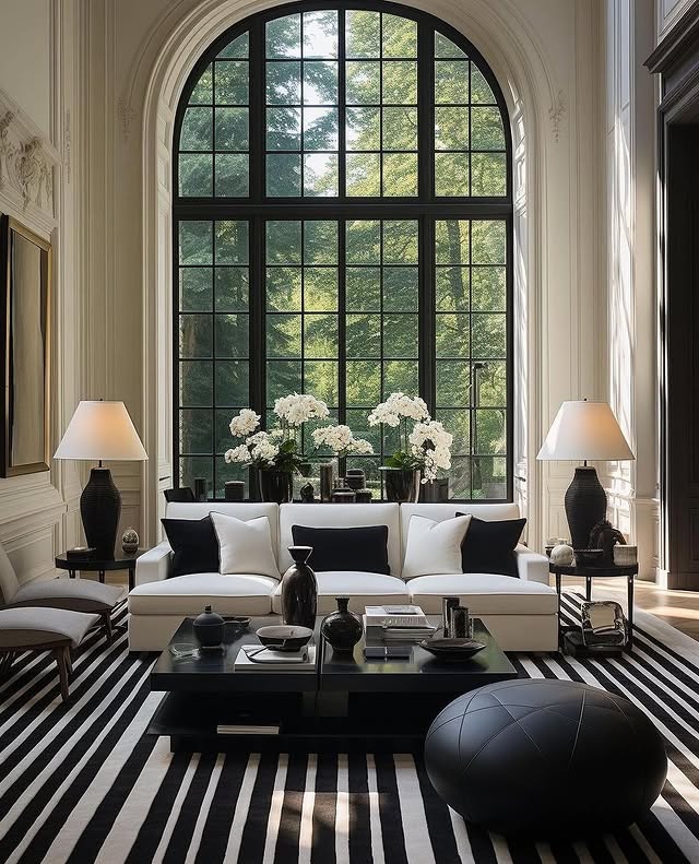 9. Elegant Black and White Living Room with Arched Windows - black and white living room ideas