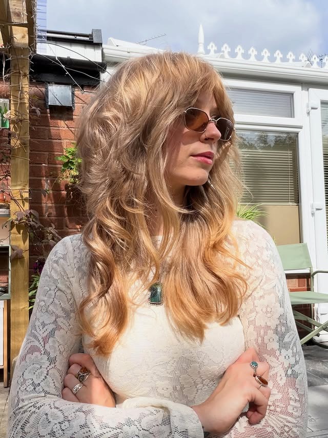 7. Sandy Blonde 70s Feathered Layers with Curtain Bangs - 70S Hairstyles