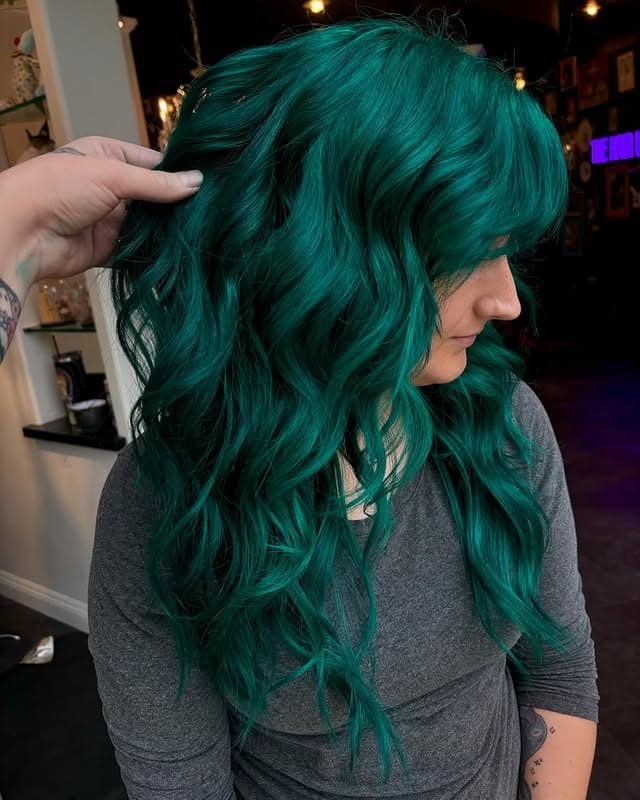 5. Emerald Teal Layered Hair with Curtain Bangs - Teal Hair Color