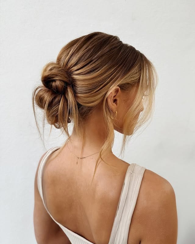 13. Low Twisted Bun with Honey Blonde Balayage - Bun Hairstyles