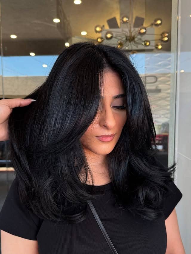 1. Soft Black Butterfly Layers with Face-Framing Curtain Bangs - Soft Black Hair Color