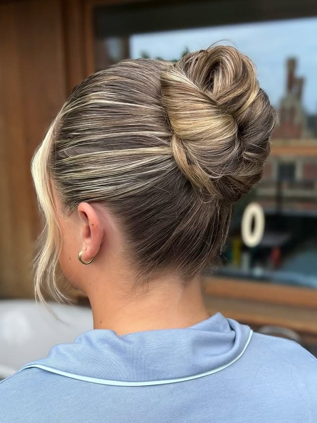 1. Champagne Blonde Sleek Twisted High Bun - Sleek Hairstyles