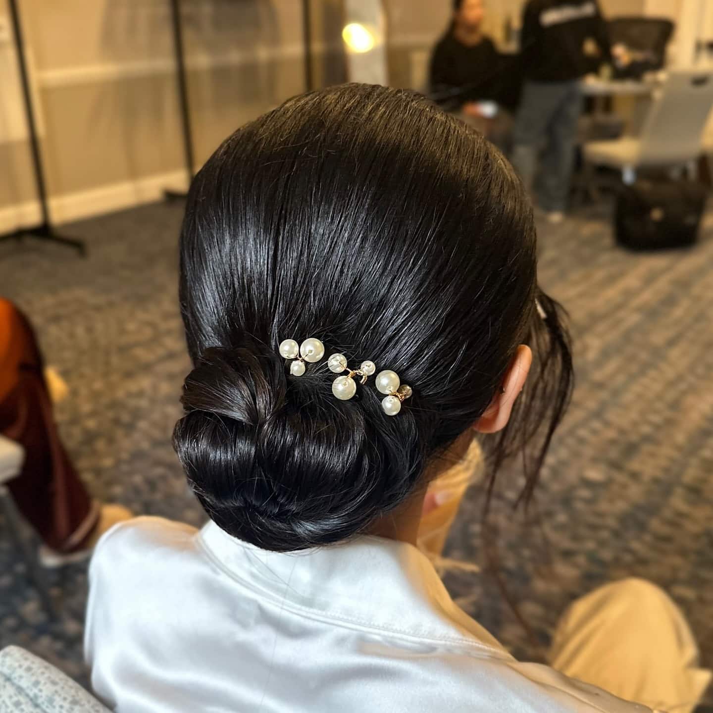 11. Jet Black Sleek Low Chignon with Pearl Pins - Sleek Hairstyles