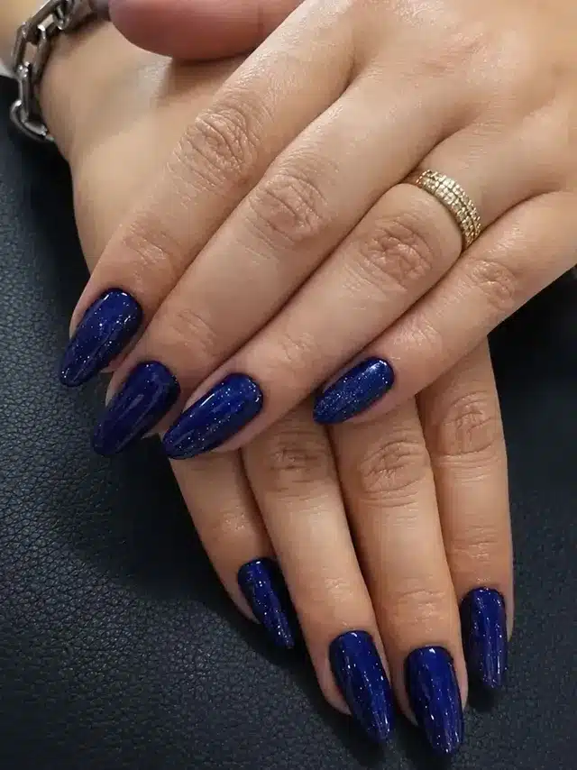3. Midnight Blue Glitter Almond Nails - dark blue nail ideas