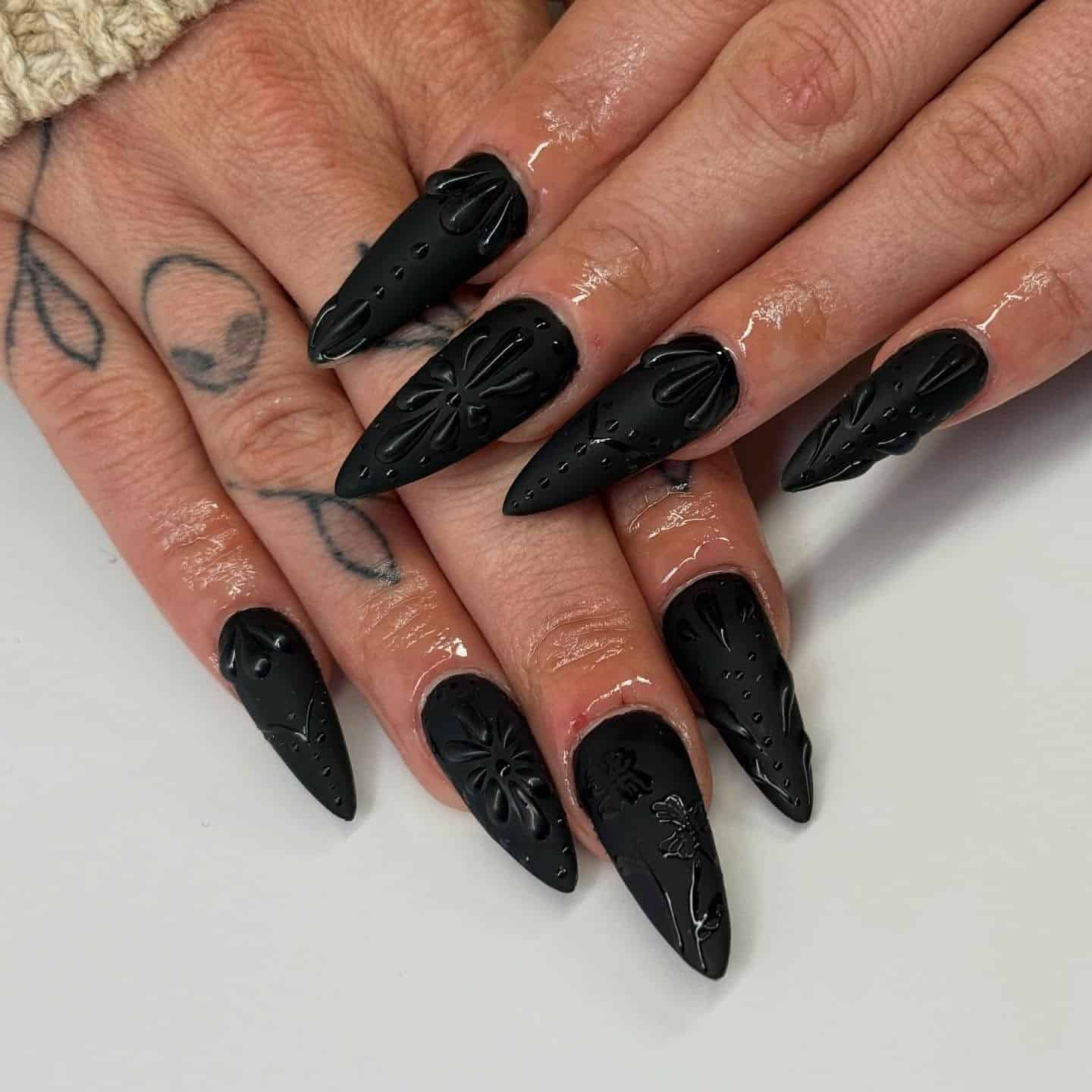 15. Matte Black Embossed Floral Stiletto Nails - matte black nail ideas
