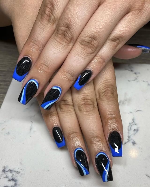 4. Glossy Black and Royal Blue Swirl Coffin Nails - black and blue nail ideas