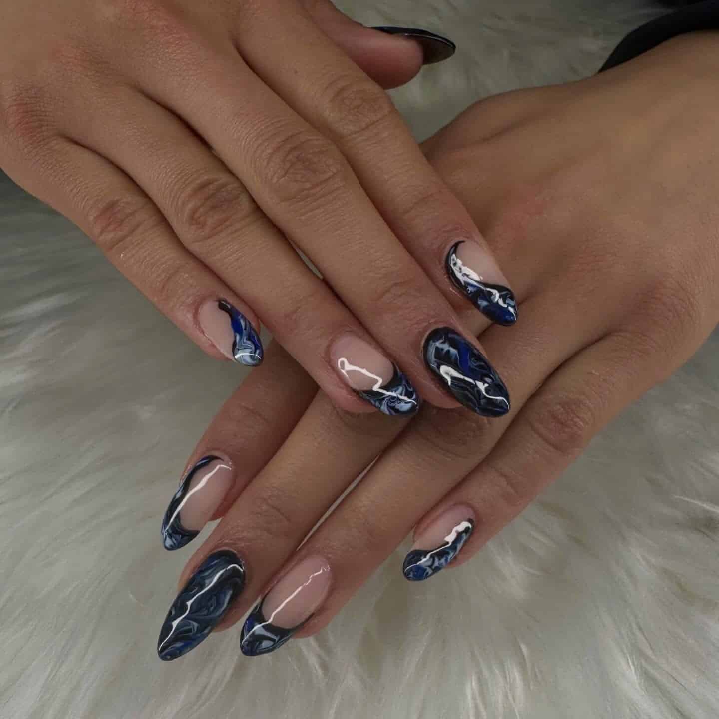 7. Nude and Navy Blue Marble Almond Nails - black and blue nail ideas