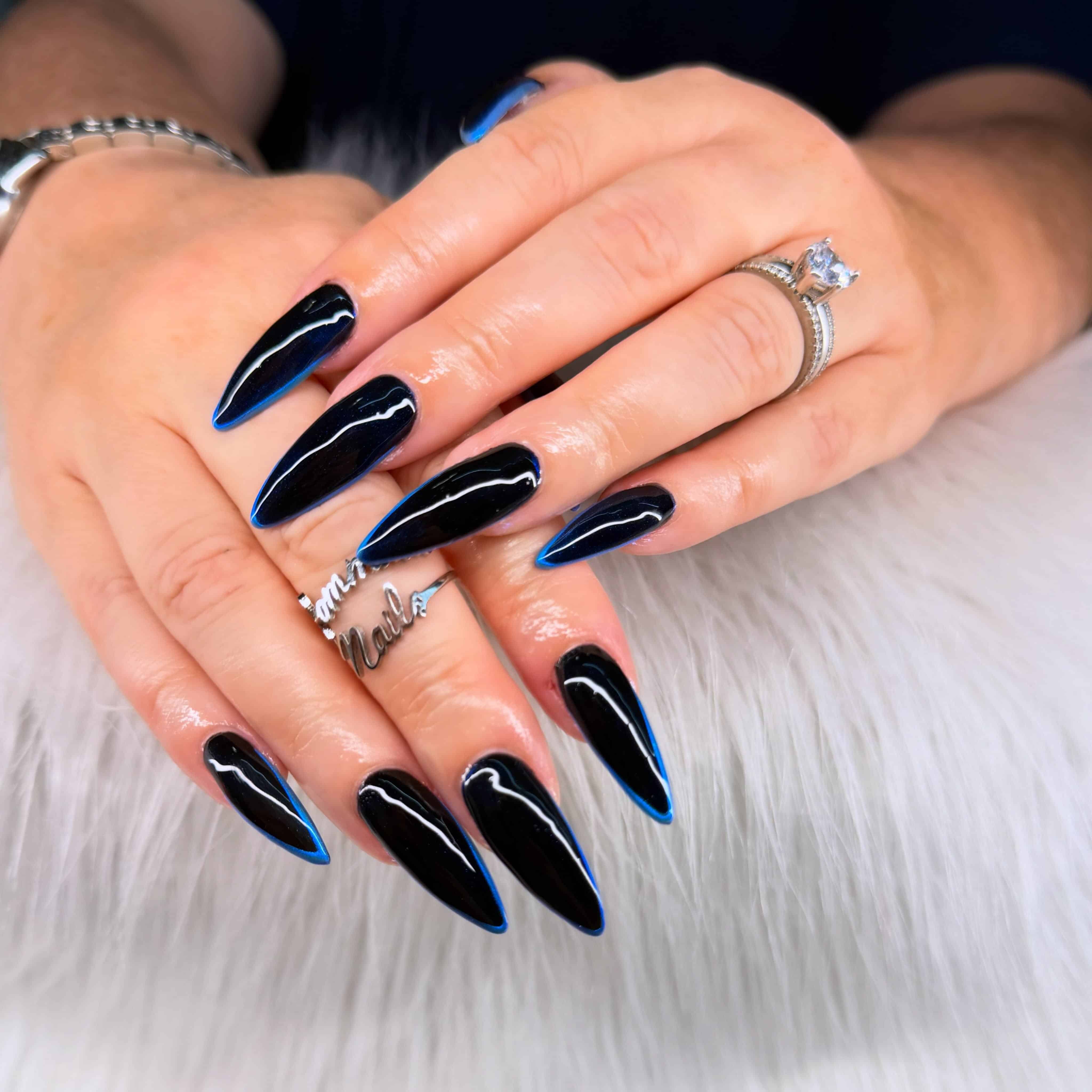 13. Glossy Black Stiletto Nails with Electric Blue Edges - black and blue nail ideas