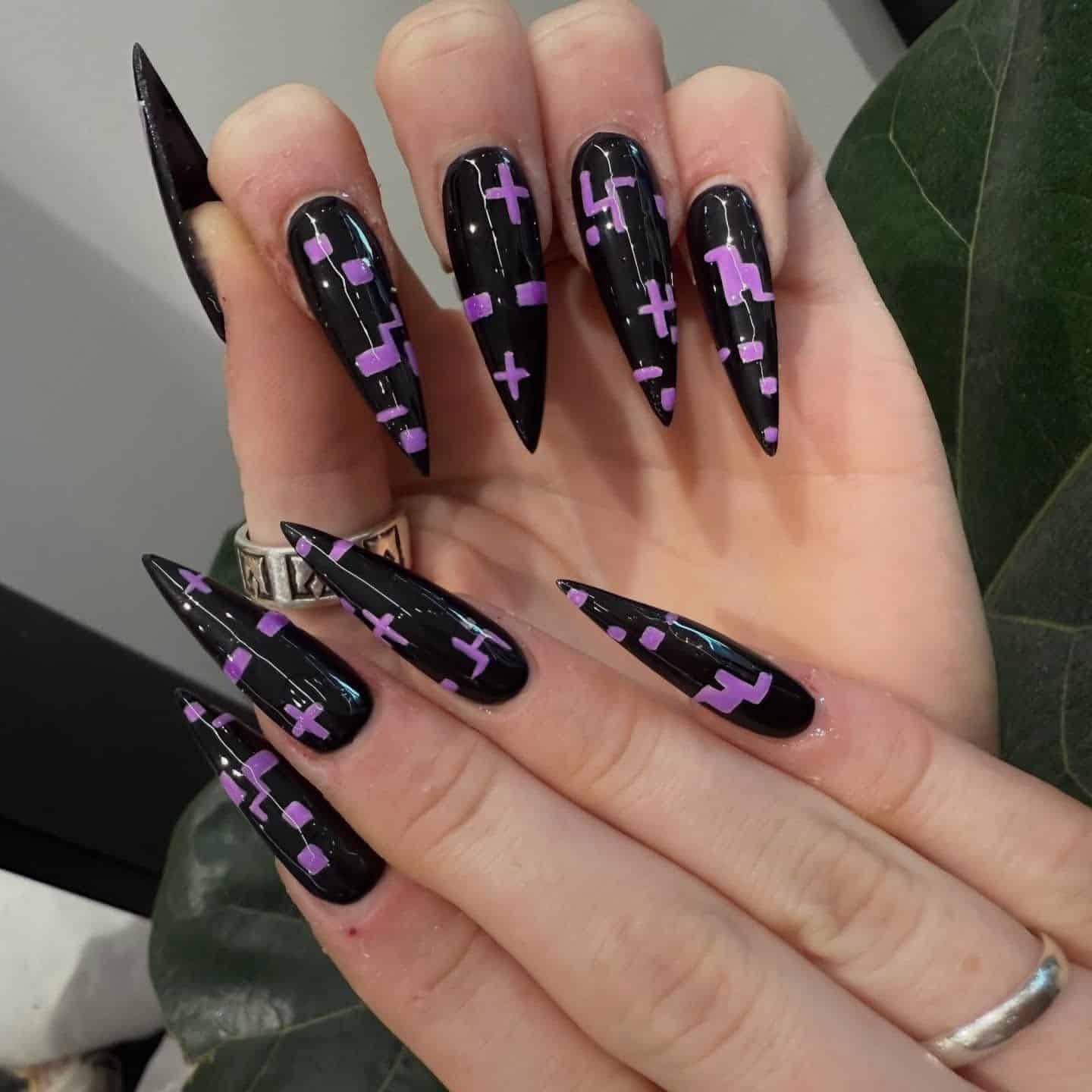 1. Glossy Black Stiletto Nails with Purple Geometric Art - black and purple nail ideas