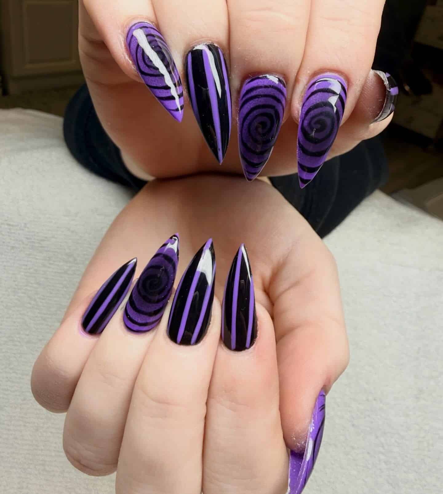 15. Purple and Black Stiletto Nails with Spiral Art - black and purple nail ideas