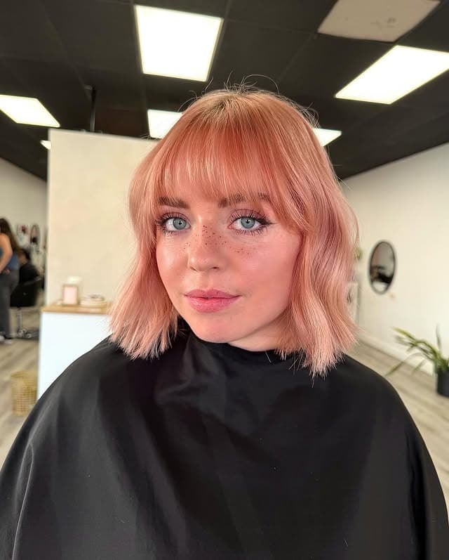 20. Peach Rose Gold Bob with Bangs - Rose Gold Hair Color