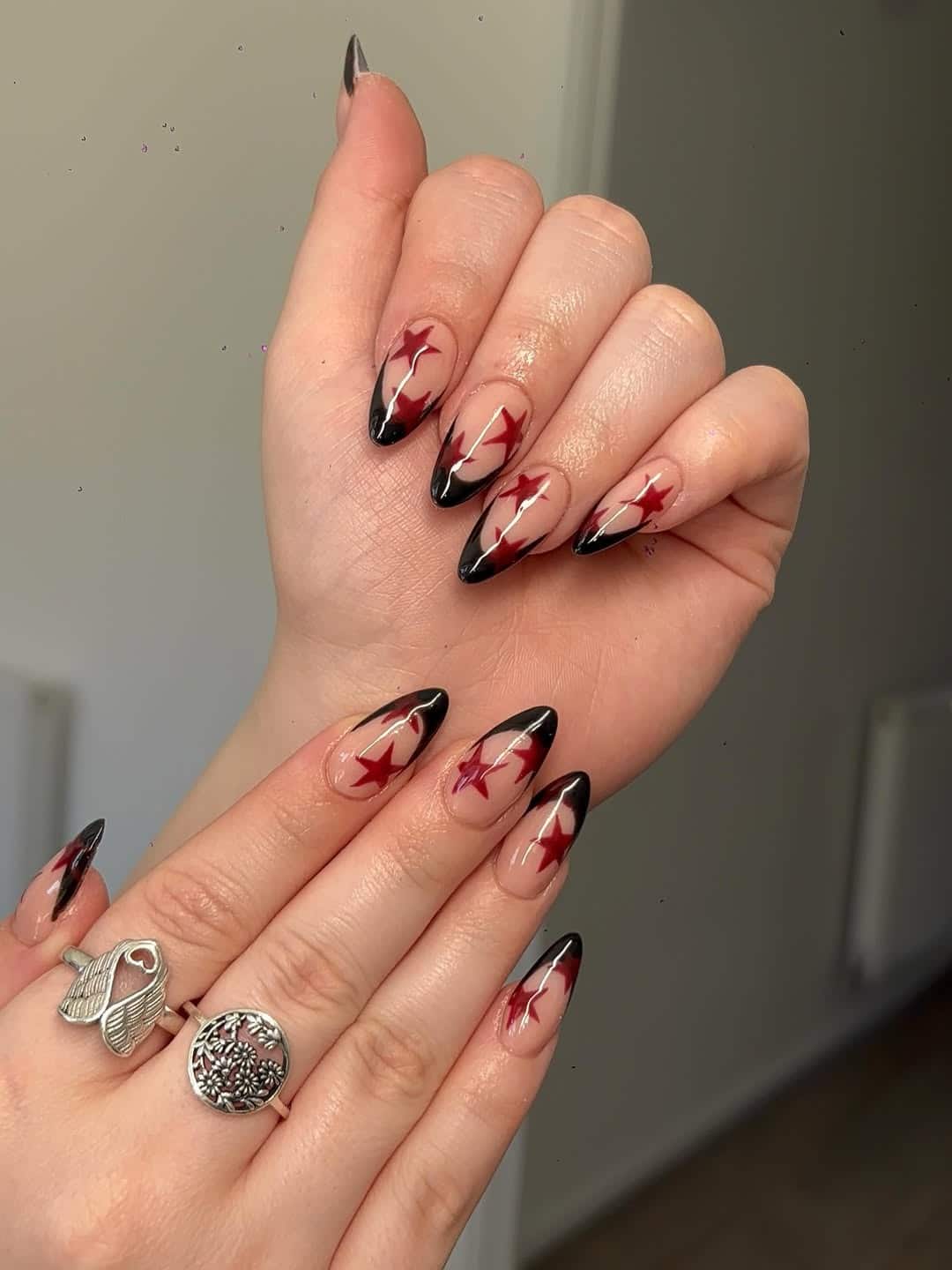 8. Nude, Black and Red Star Almond Nails - star nail ideas