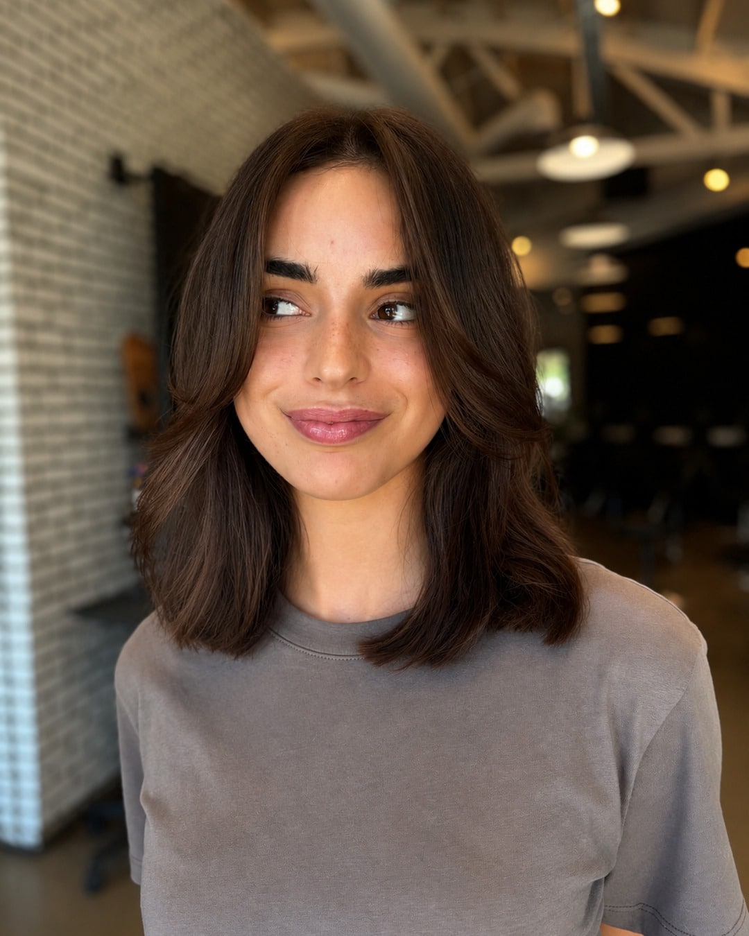 9. Warm Chestnut Brown Layered Lob with Curtain Bangs - Face-Framing Haircuts