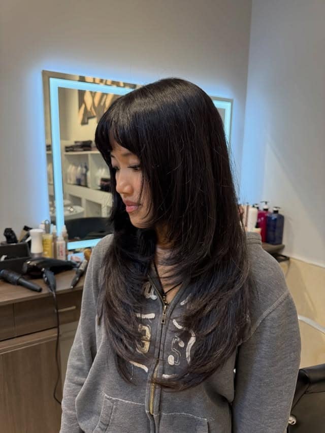 11. Soft Black Butterfly Haircut with Wispy Face-Framing Bangs - Face-Framing Haircuts