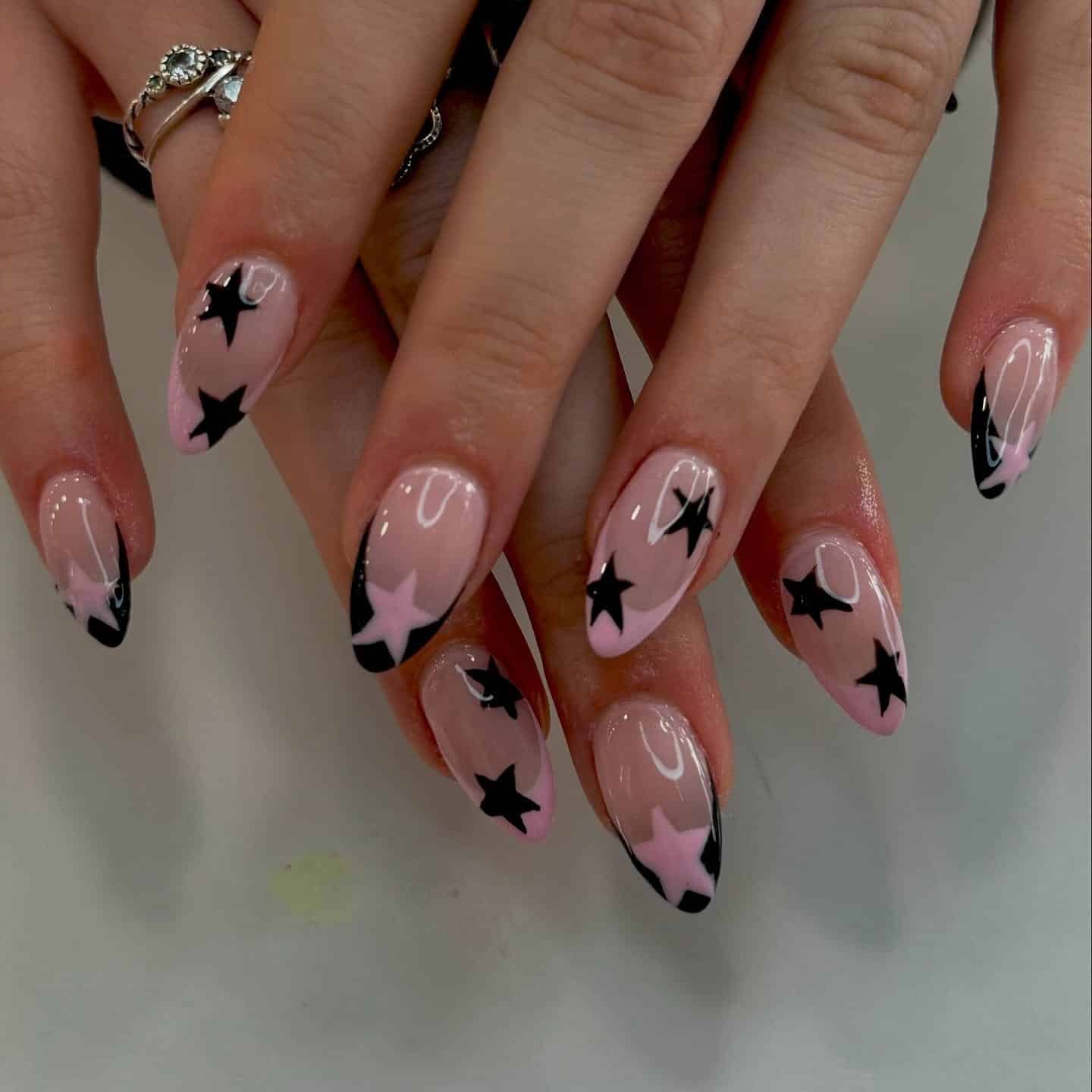 19. Soft Pink and Black Star Almond Nails - black and pink nail ideas