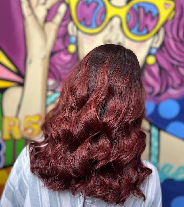 11. Vibrant Cherry Mahogany Hair with Glossy Voluminous Waves - Mahogany Hair Color