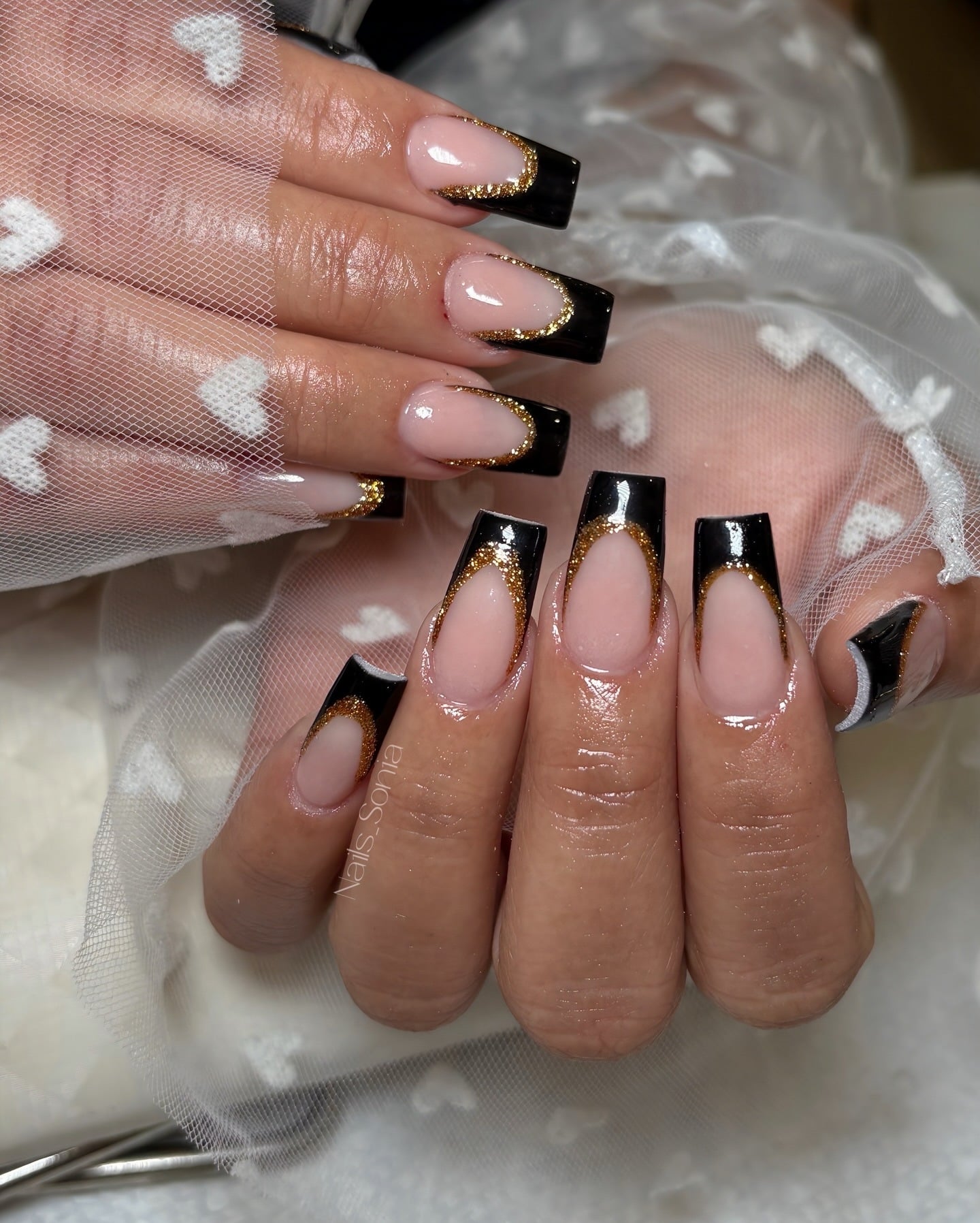 7. Black and Gold Coffin Nails with Curved French Tips - black coffin nail ideas