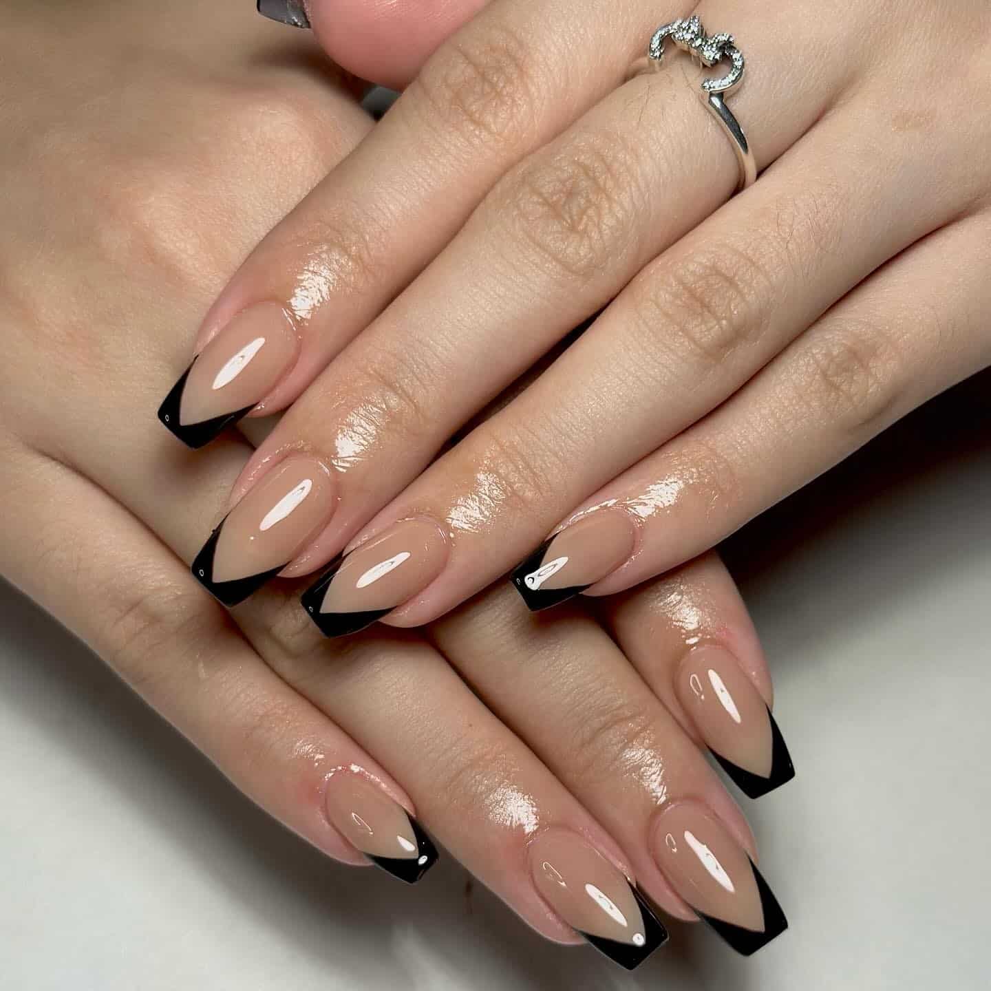 18. Nude Coffin Nails with Black V-Shaped French Tips - black coffin nail ideas