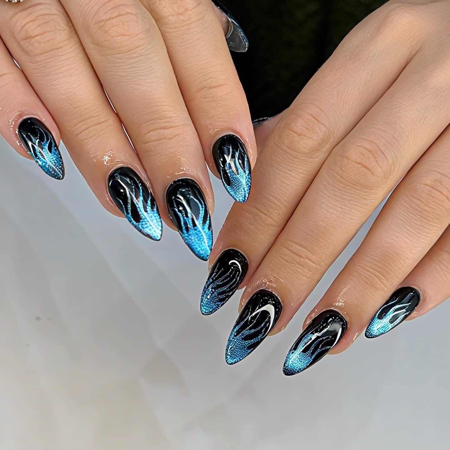 2. Black Stiletto Nails with Electric Blue Flame Art - blue and black nail ideas