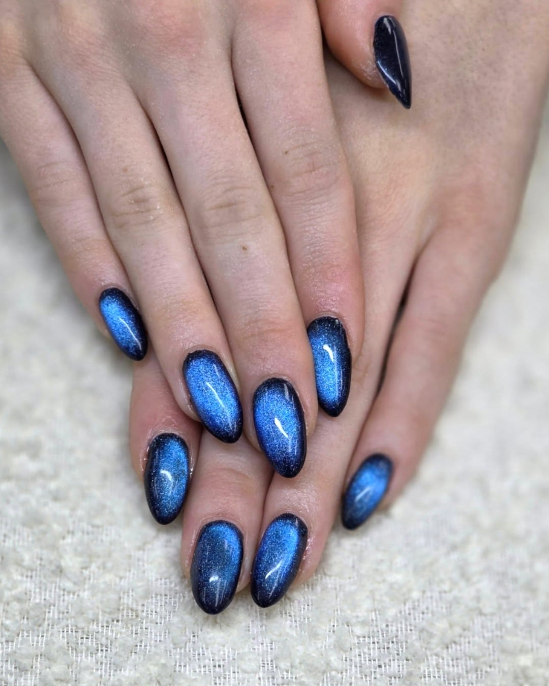 9. Shimmering Cobalt Blue and Black Cat Eye Nails - blue and black nail ideas