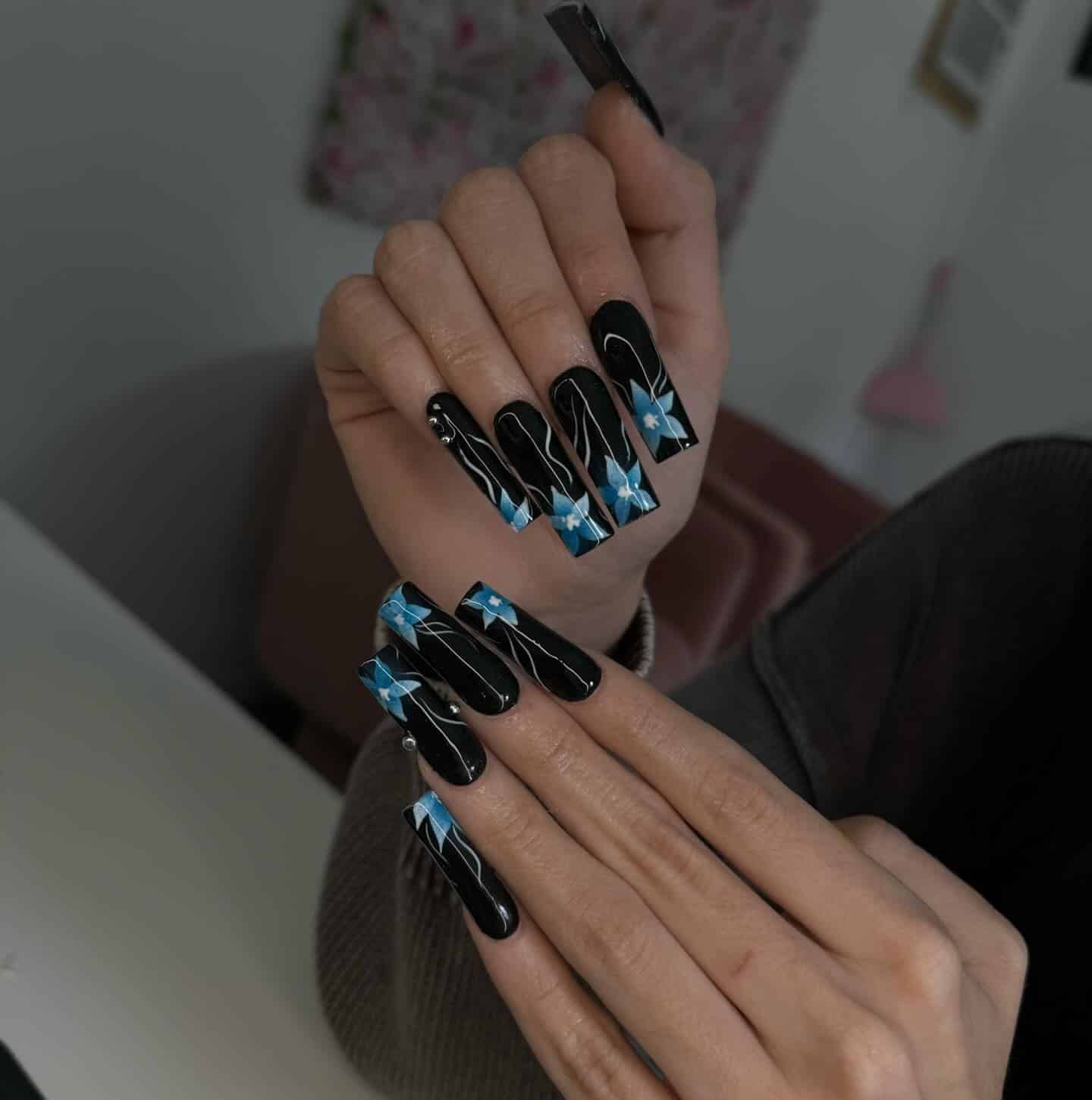14. Glossy Black Coffin Nails with Blue Floral Art - blue and black nail ideas
