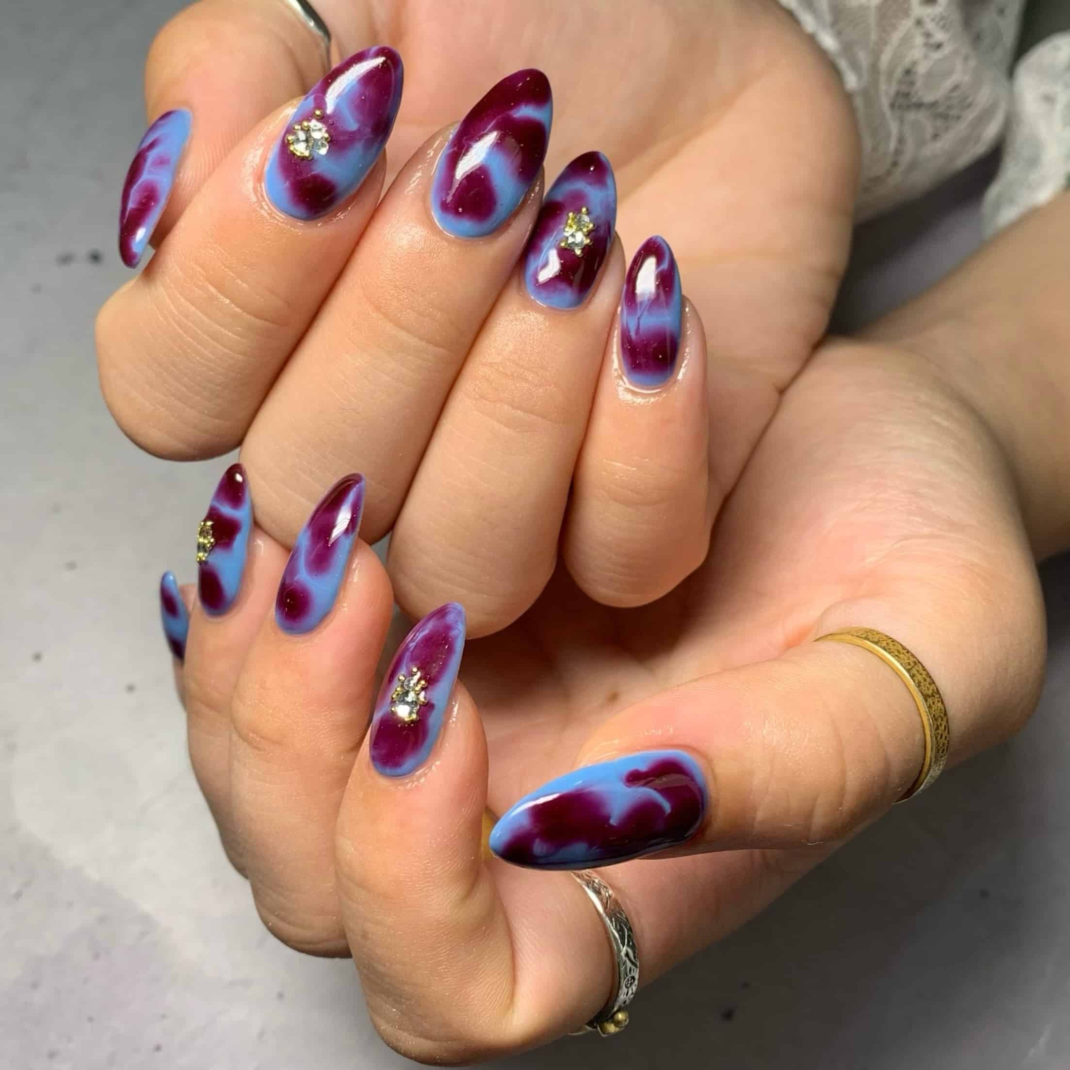 11. Burgundy Purple and Blue Marble Almond Nails - blue and purple nail ideas