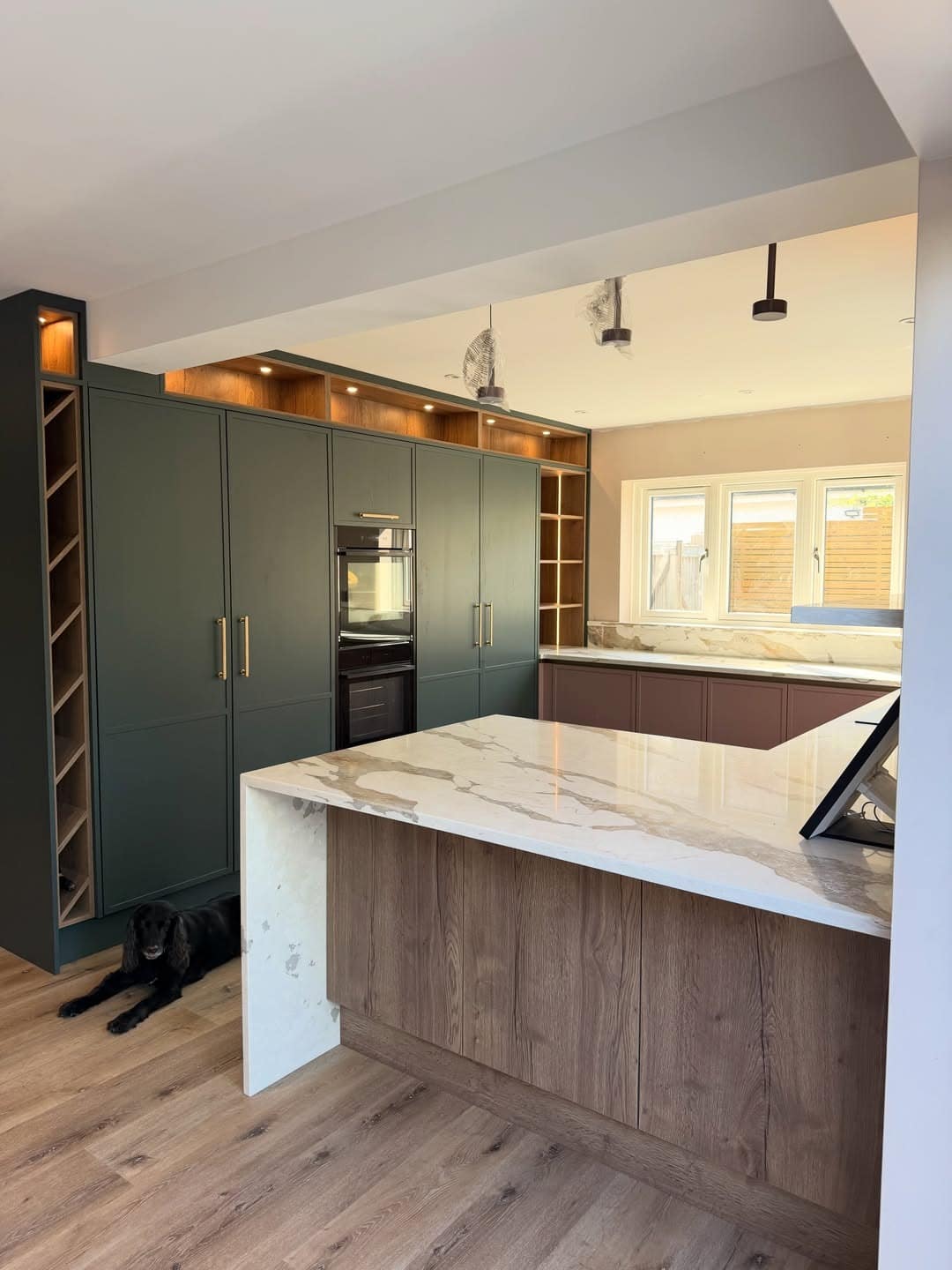 7. Deep Forest Green Kitchen Cabinet Feature Wall with White Marble Accents - feature wall kitchen ideas