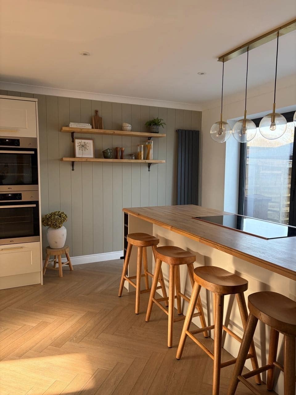 21. Muted Sage Green Vertical Paneled Kitchen Feature Wall with Natural Oak Accents - feature wall kitchen ideas