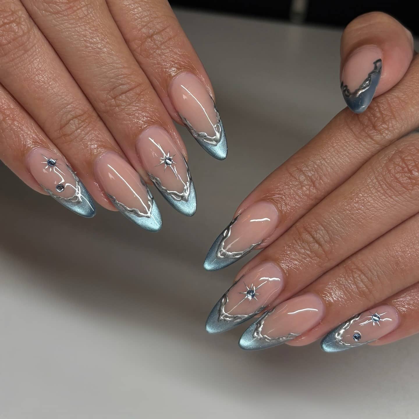 7. Metallic Ice Blue French Tips with Silver Starbursts - blue and silver nail ideas