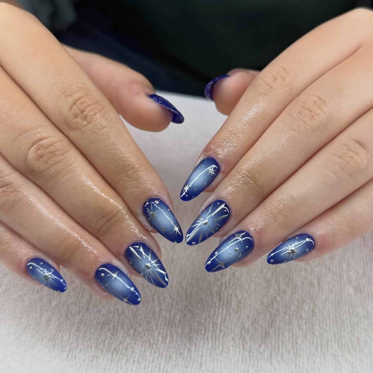 11. Midnight Blue Cat Eye Nails with Silver Stars - blue and silver nail ideas