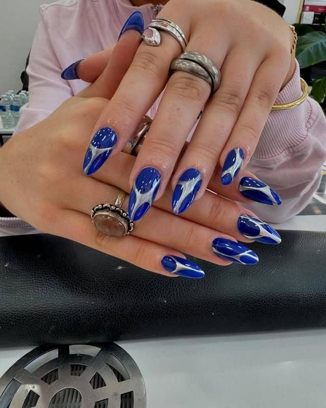 14. Cobalt Blue Almond Nails with Silver Abstract Swirls - blue and silver nail ideas