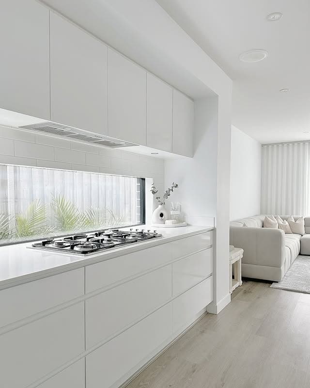 19. Scandinavian White Kitchen with Light Gray Wood Flooring - all white kitchen ideas