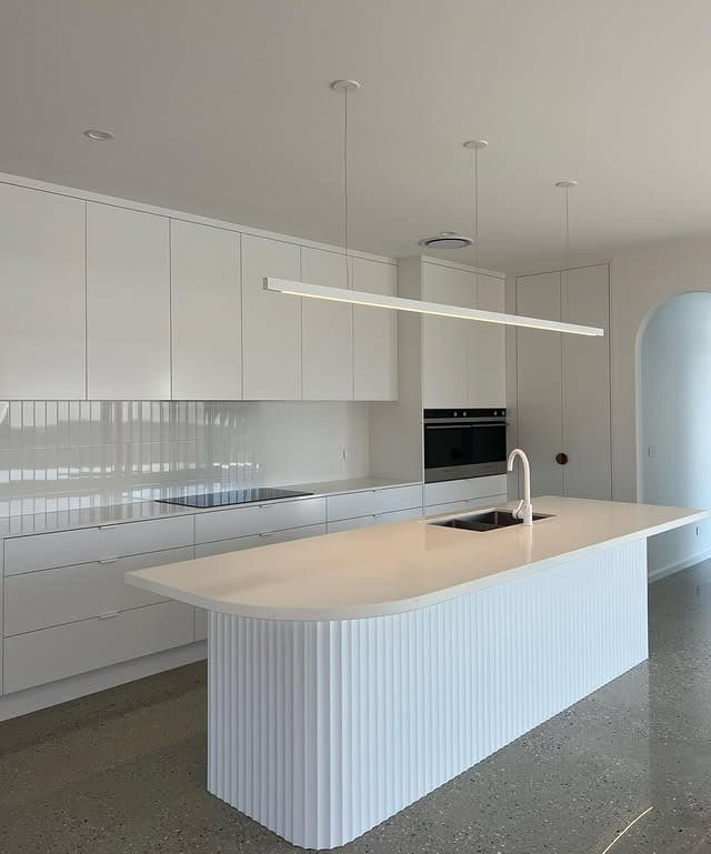 20. Contemporary White Kitchen with Fluted Island Design - all white kitchen ideas