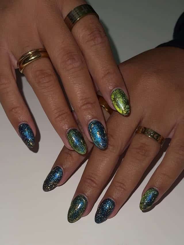 1. Emerald Green and Sapphire Blue Glitter Galaxy Almond Nails - galaxy nail ideas