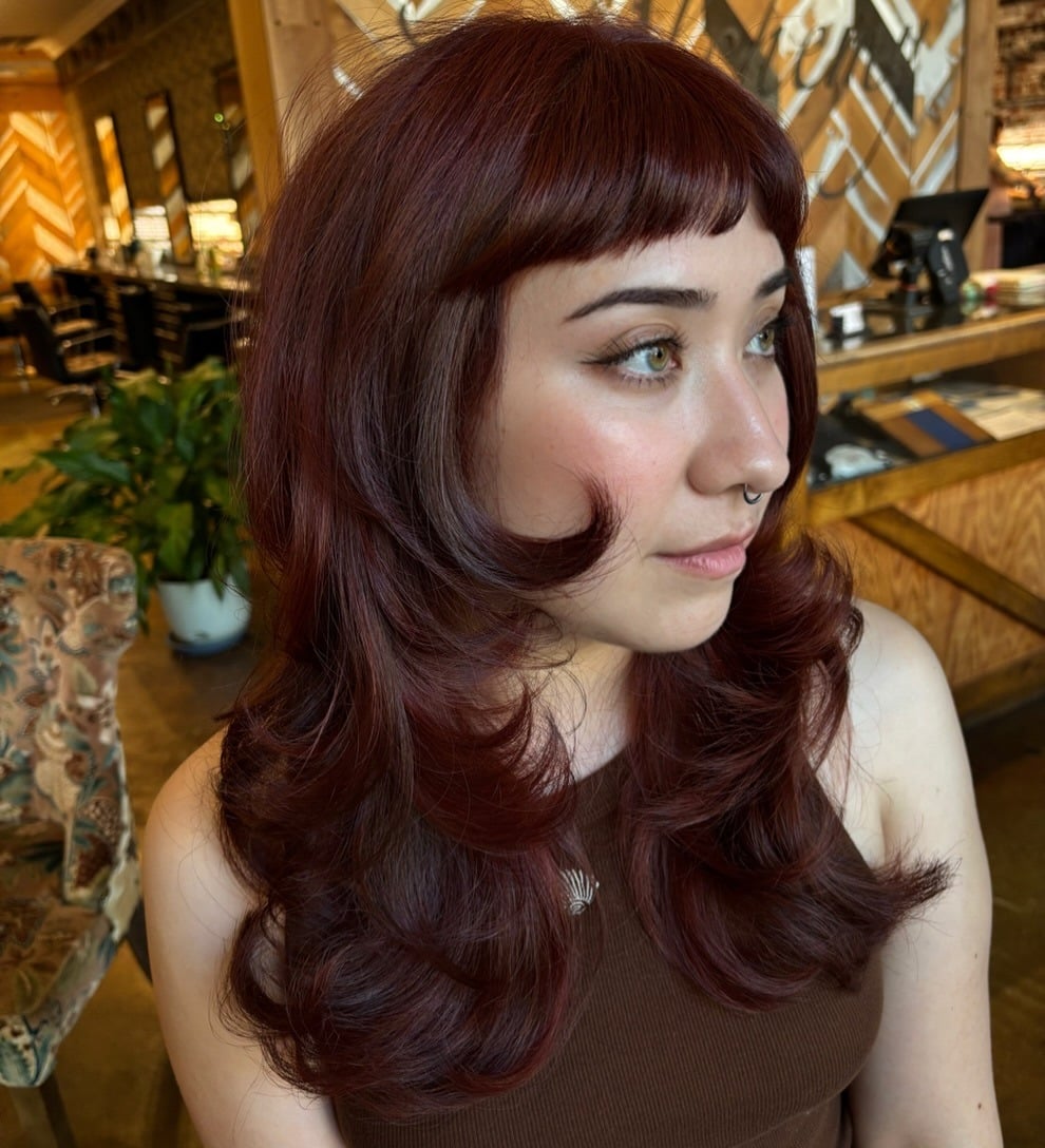 2. Deep Burgundy Auburn Hair with Butterfly Layers and Micro Bangs - Dark Auburn Hair Color